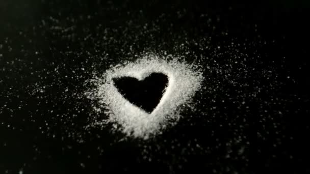 Heart drawn into sugar being blown out by wind — Stock Video