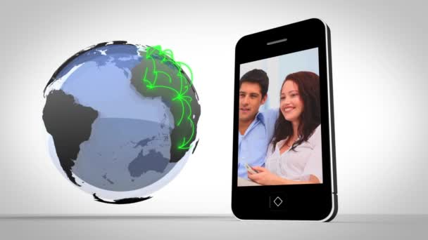 Vídeo de casais apresentados no smartphone ao lado do globo — Vídeo de Stock