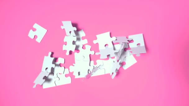 Puzzel vallen op roze oppervlak — Stockvideo