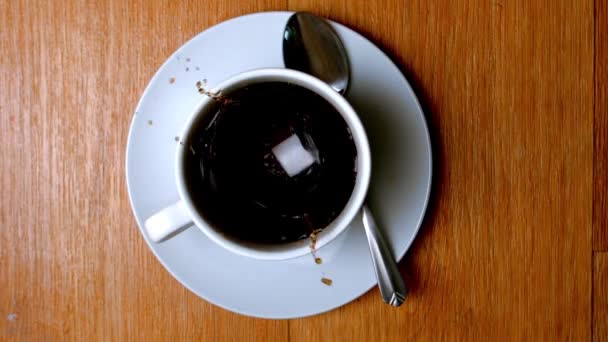 Кусок сахара падает в чашку кофе — стоковое видео