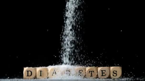 Azúcar en polvo que se vierte sobre dados deletreando la diabetes — Vídeos de Stock