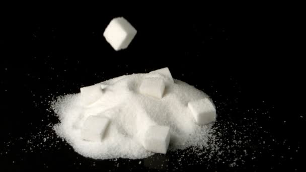 Sugar cube falling in pile of sugar powder — Stock Video