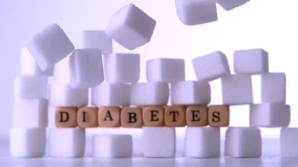 Pared de terrones de azúcar con dados deletreando la diabetes — Vídeo de stock