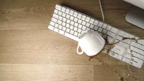 Cup of tea spilled out over a white keyboard — Stock Video