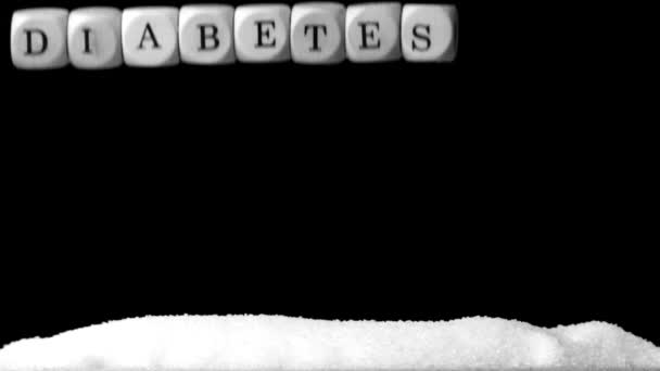Weiße Würfel, die Diabetes buchstabieren, fallen über einen Haufen Zucker — Stockvideo
