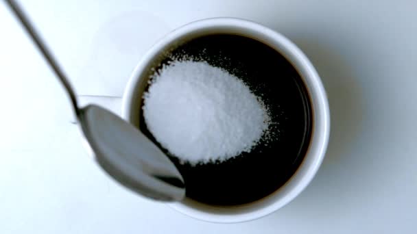 Κουταλάκι του γλυκού ρίχνει ζάχαρη στο φλιτζάνι του καφέ — Αρχείο Βίντεο