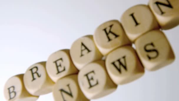 Breaking news spelled out in dice falling on white surface — Stock Video