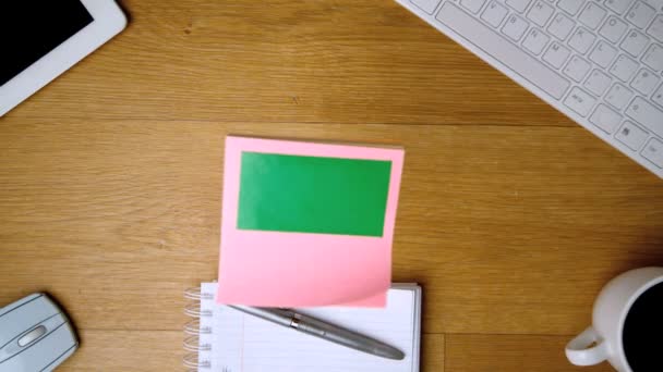 Pink sticky notes with chroma key falling onto office desk — Stock Video