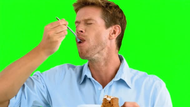 Человек наслаждается вкусный торт на зеленом экране — стоковое видео