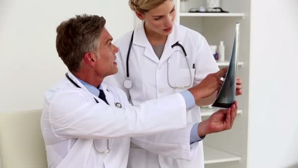 Lekarze badający rentgen — Wideo stockowe