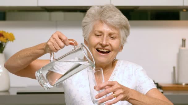 Счастливая женщина наливает стакан воды — стоковое видео