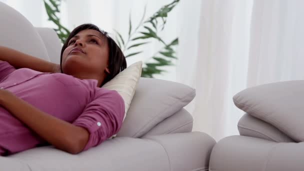 Женщина отдыхает на диване — стоковое видео
