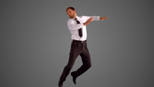 Businessman jumping and stretching on grey background — Stock Video