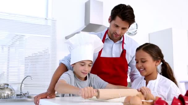 Father watching son roll pastry with sister — Stock Video