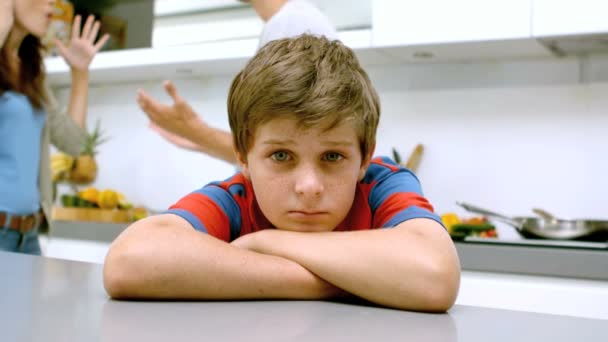 Trieste jongen met armen gevouwen terwijl ouders ruzie — Stockvideo
