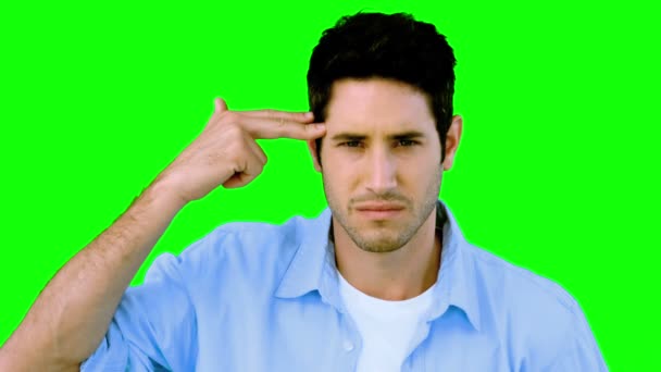 Man pretending to shoot himself with hand on green screen — Stock Video