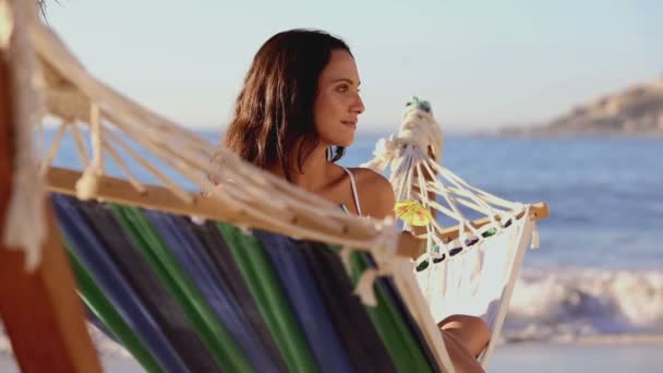 Cute woman holding a cocktail in a hammock — Stock Video