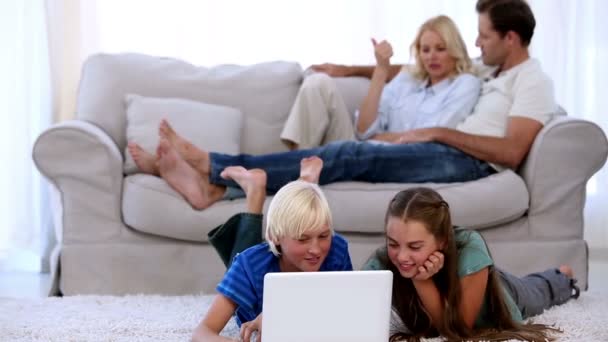 Ouders ontspannen op Bank met kinderen met behulp van laptop — Stockvideo