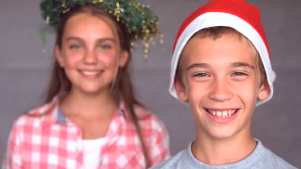 Hermanos sonrientes con sombrero de Navidad — Vídeo de stock