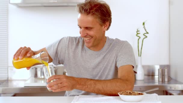 Uomo versando succo d'arancia nel suo bicchiere — Video Stock