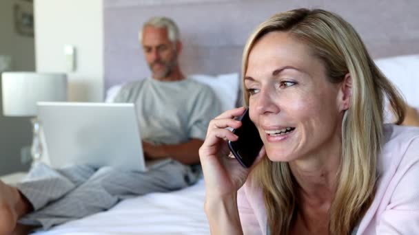 Woman hanging up the phone and talking to her husband — Stock Video