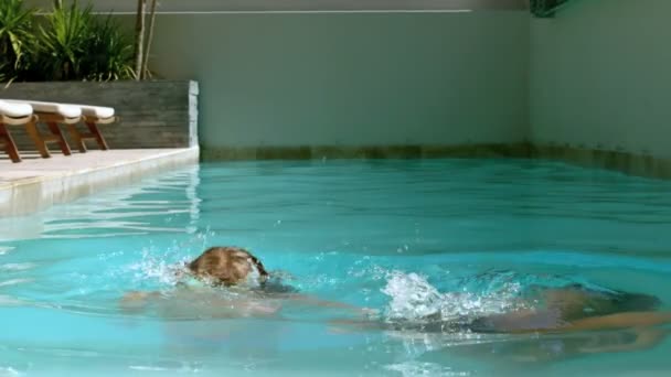 Siblings having fun in the swimming pool — Stock Video