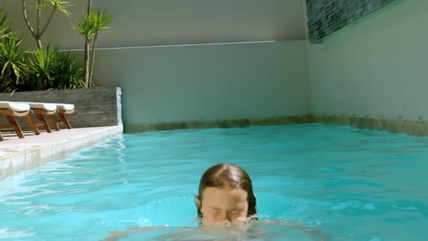 Chica joven divirtiéndose en la piscina — Vídeo de stock