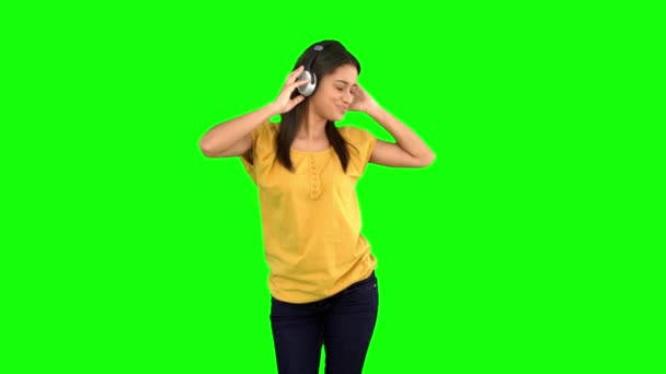 Mulher dançando com fones de ouvido na tela verde — Vídeo de Stock