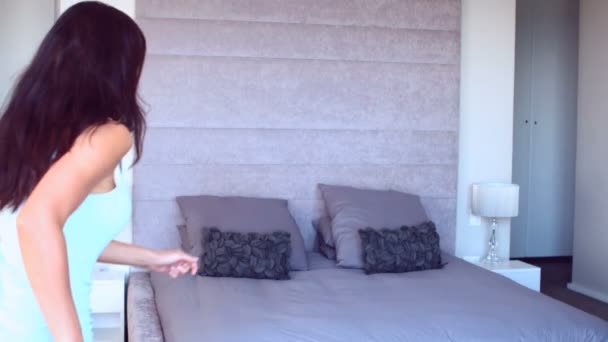 Красивая женщина прыгает на кровать — стоковое видео