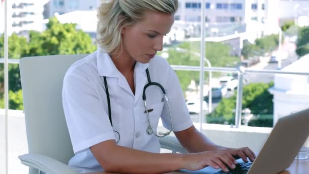 Krankenschwester tippt an ihrem Schreibtisch — Stockvideo