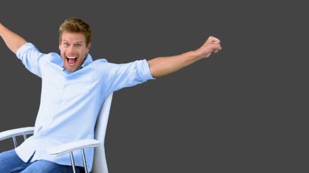 Man on swivel chair raising arms to show his success on grey screen — Stock Video