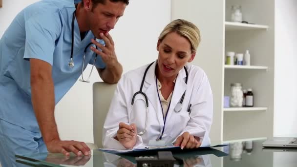 Ärzte untersuchen gemeinsam ein Dokument — Stockvideo