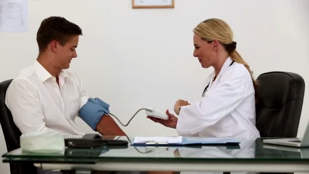 Female doctor checking patient blood pressure — Stock Video