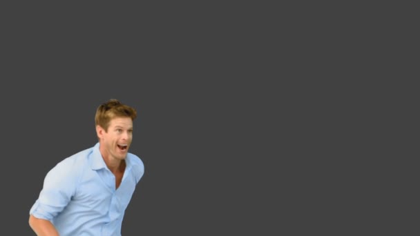 Smiling man jumping on grey screen — Stock Video