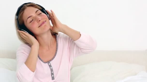 Blondynka korzystających muzyki w sypialni — Wideo stockowe