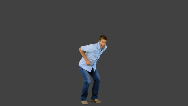 Homem pulando e gesticulando na tela cinza — Vídeo de Stock