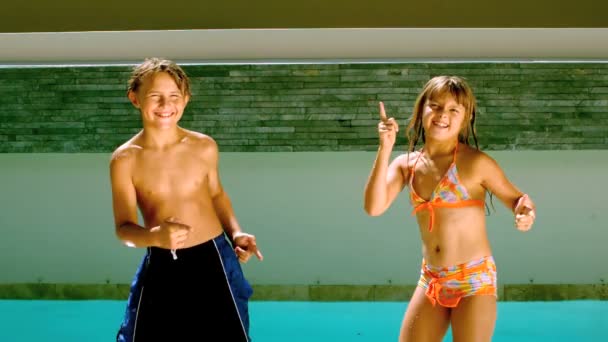 Irmãos dançando juntos em frente à piscina — Vídeo de Stock