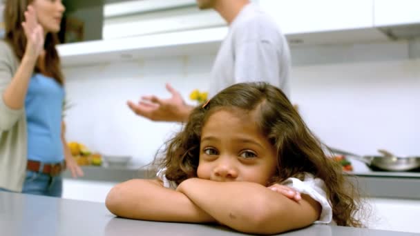 Sad girl with arms folded while parents quarreling — Stock Video