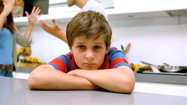 Trieste jongen met armen gevouwen terwijl ouders ruzie — Stockvideo