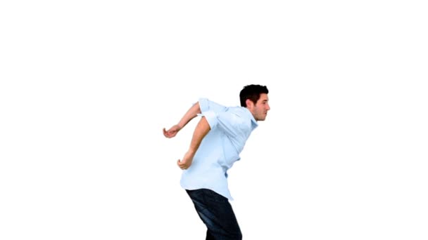 Молодой человек прыгает на белом фоне — стоковое видео