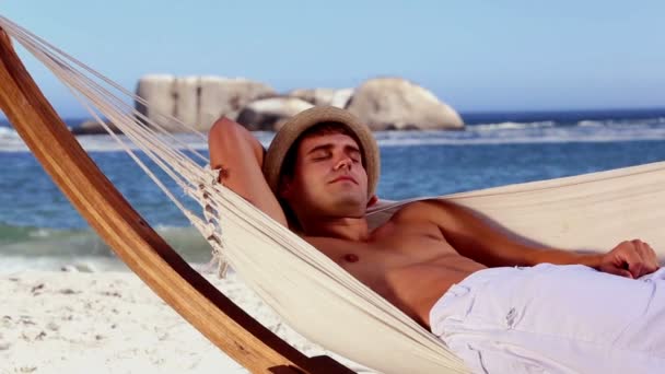 Homem relaxante em uma rede na praia — Vídeo de Stock