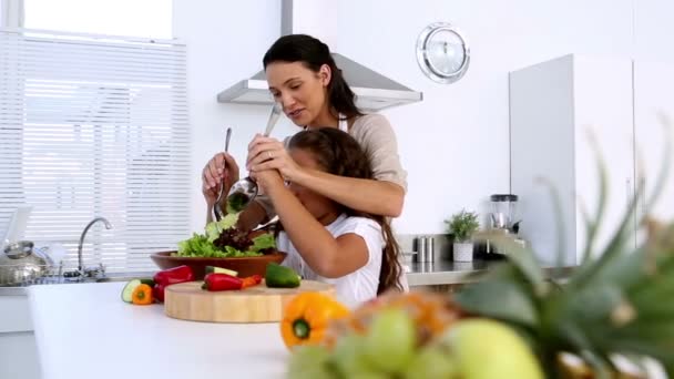 Mother and daughter tossing salad together — Stock Video