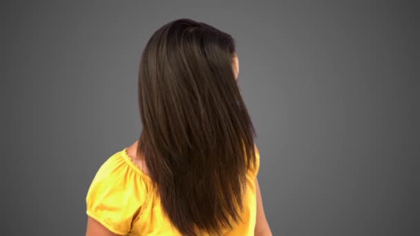 Usmívající se žena házel vlasy na šedém pozadí — Stock video
