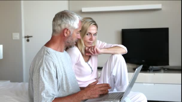 Пара, використовуючи ноутбук разом і балачки — стокове відео
