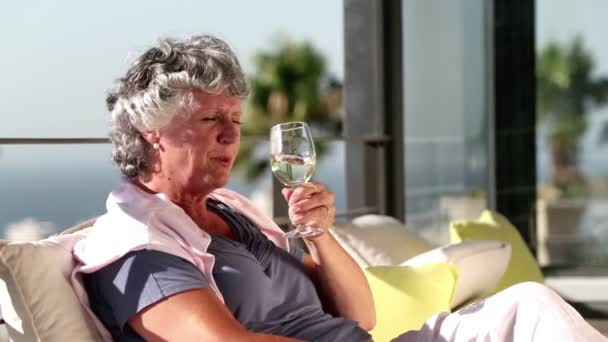 Mujer madura disfrutando de una copa de vino en el balcón — Vídeos de Stock