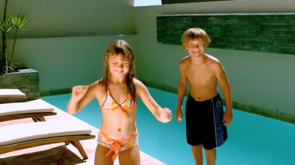 Menina dançando enquanto irmão pulando na piscina — Vídeo de Stock