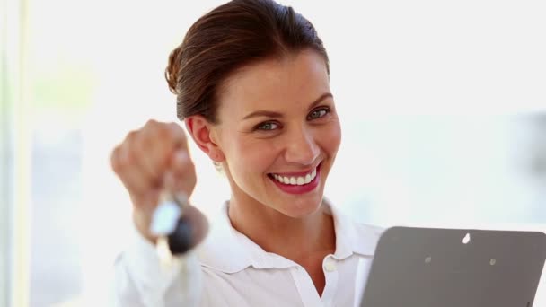 Mulher de negócios sorridente balançando chaves na frente da câmera — Vídeo de Stock