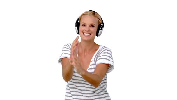 Young woman listening to music on white background — Stock Video