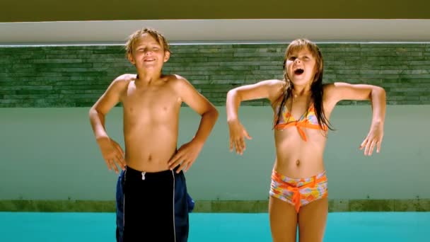 Siblings dancing and diving into the swimming pool — Stock Video