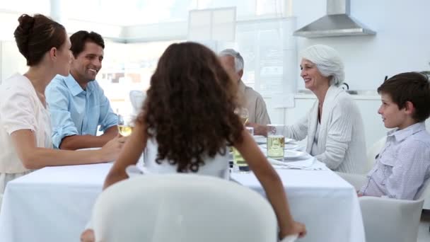 Family sitting at dinner table and toasting — Stock Video